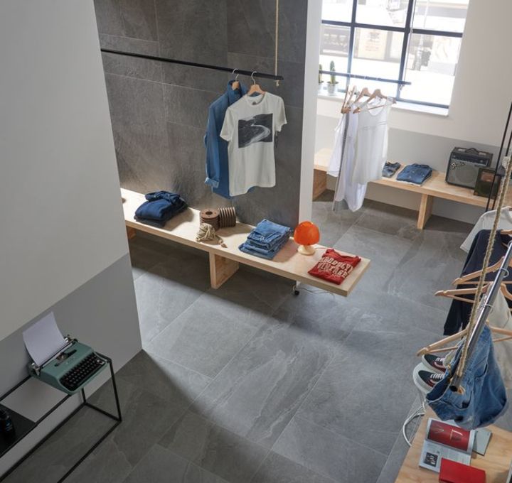 Grijze vloertegels in betonlook in een moderne kledingwinkel met industriële sfeer