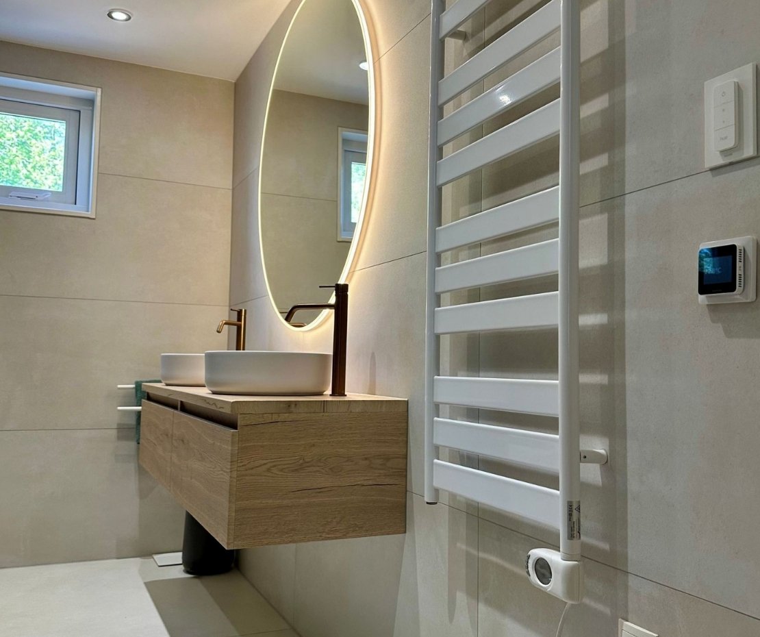 Scandinavische badkamer met grote ronde spiegel en houtlook meubel