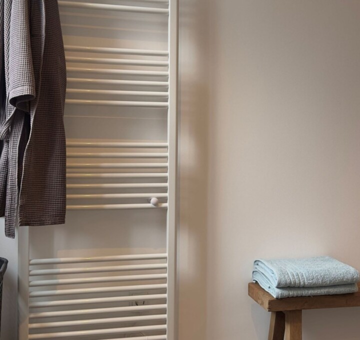 Close up van handdoeken en radiator in Scandinavische badkamer inspiratie
