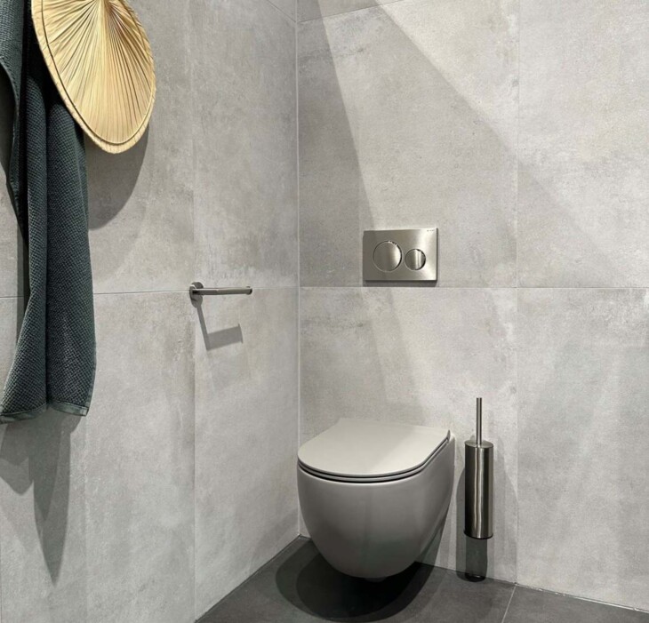 Industrieel toilet met grote betonlook wandtegels