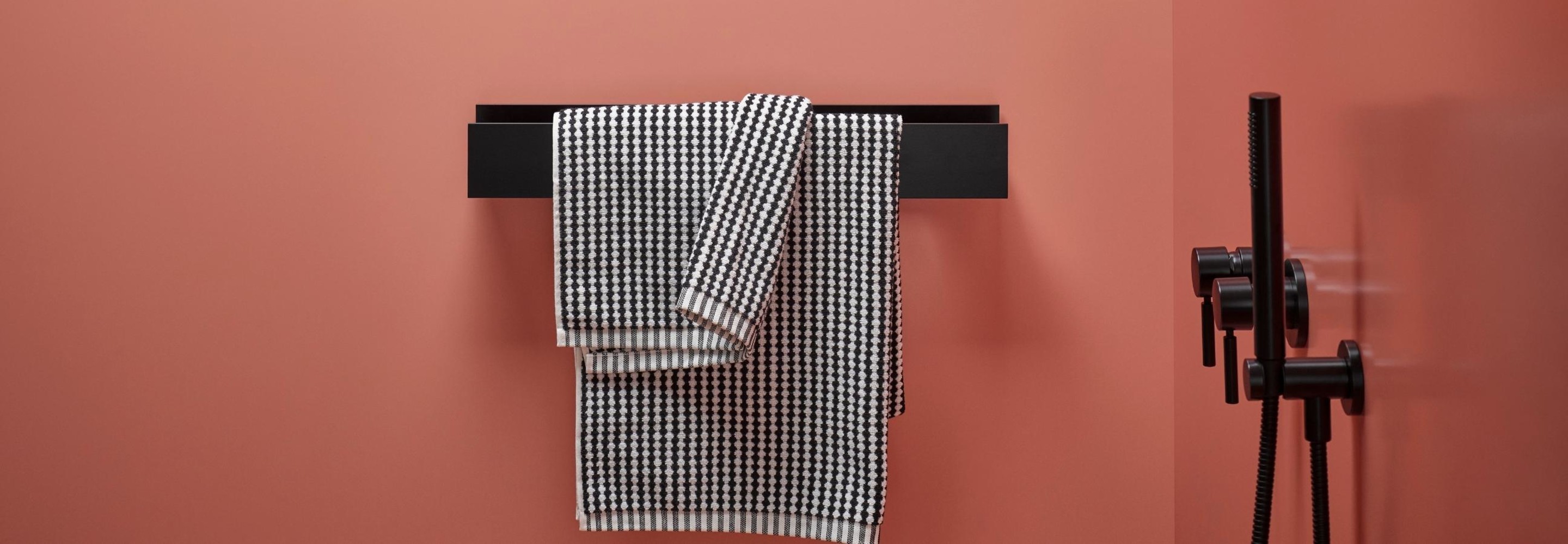 roze badkamerwand met zwarte accessoires