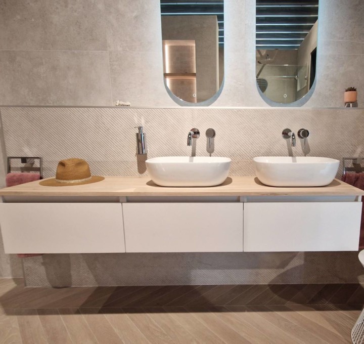 Zwevend wastafelmeubel met lichte wandtegels en warme houtlook vloer